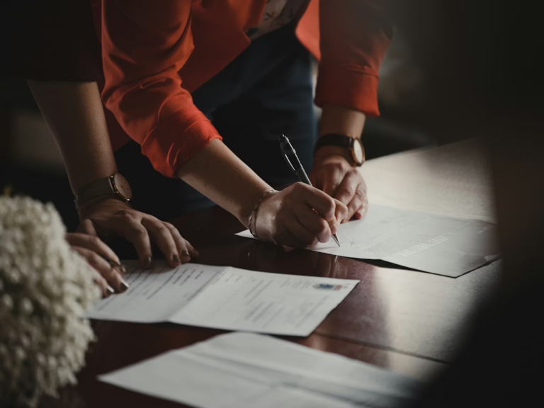 Parent and adult child reviewing mortgage co-signer documents with a lender for an Edmonton home purchase