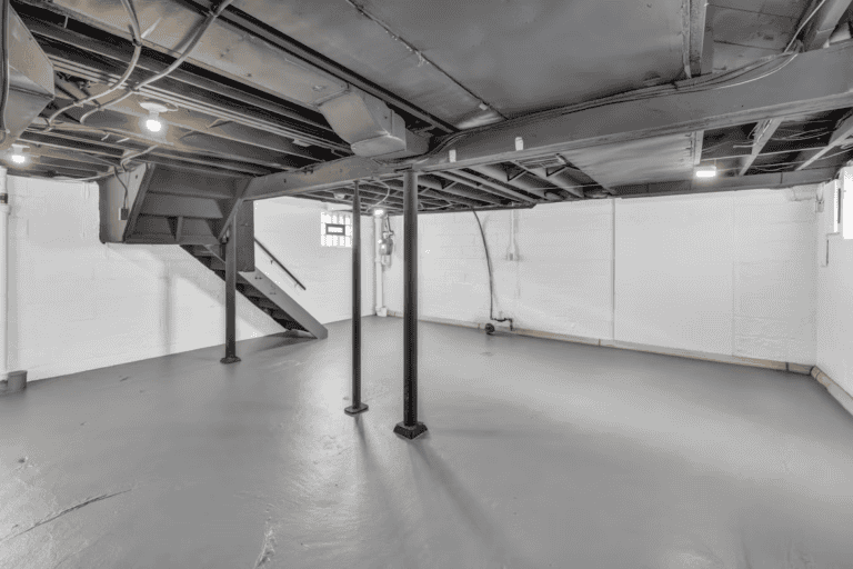 Flooded basement floor in an Edmonton home after a summer storm, standing water near mechanical room