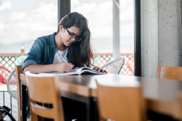 Realtor studying course materials for real estate designations in Canada at a desk